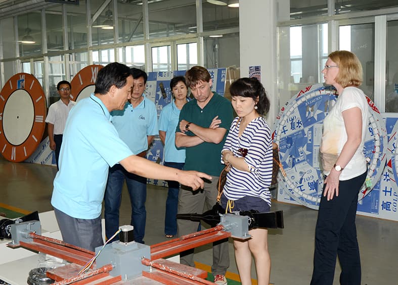 Team presenting a clock mechanism to visiting guests.