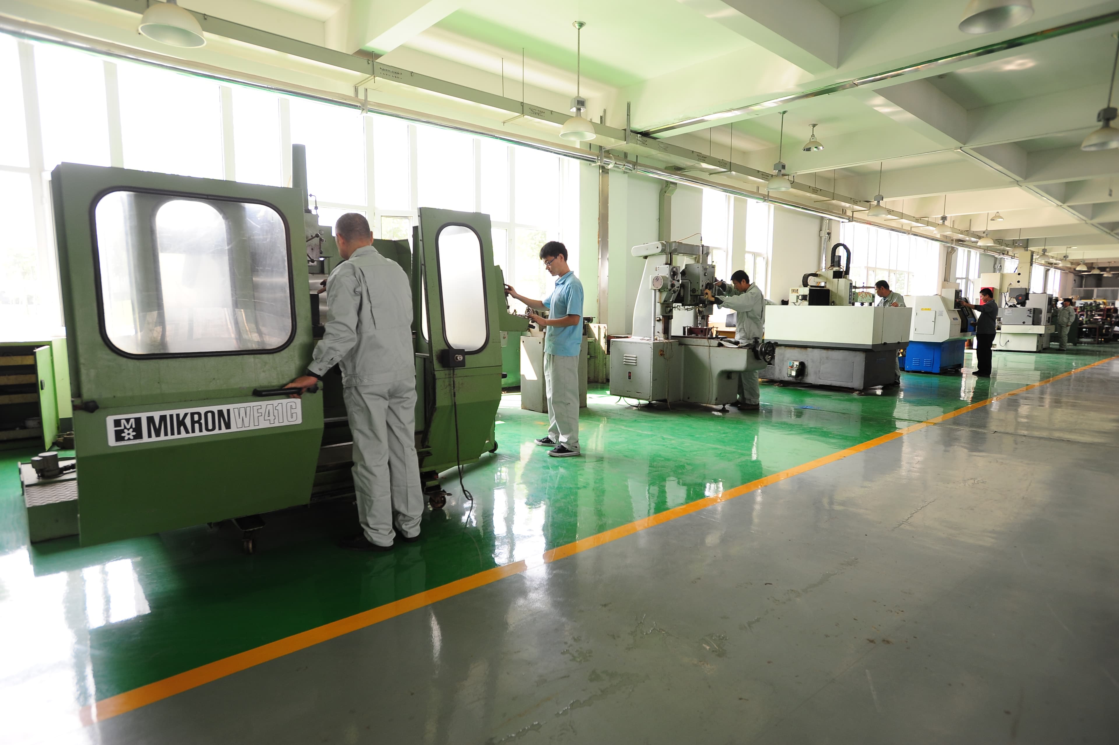 Technicians operating precision machinery in the factory.