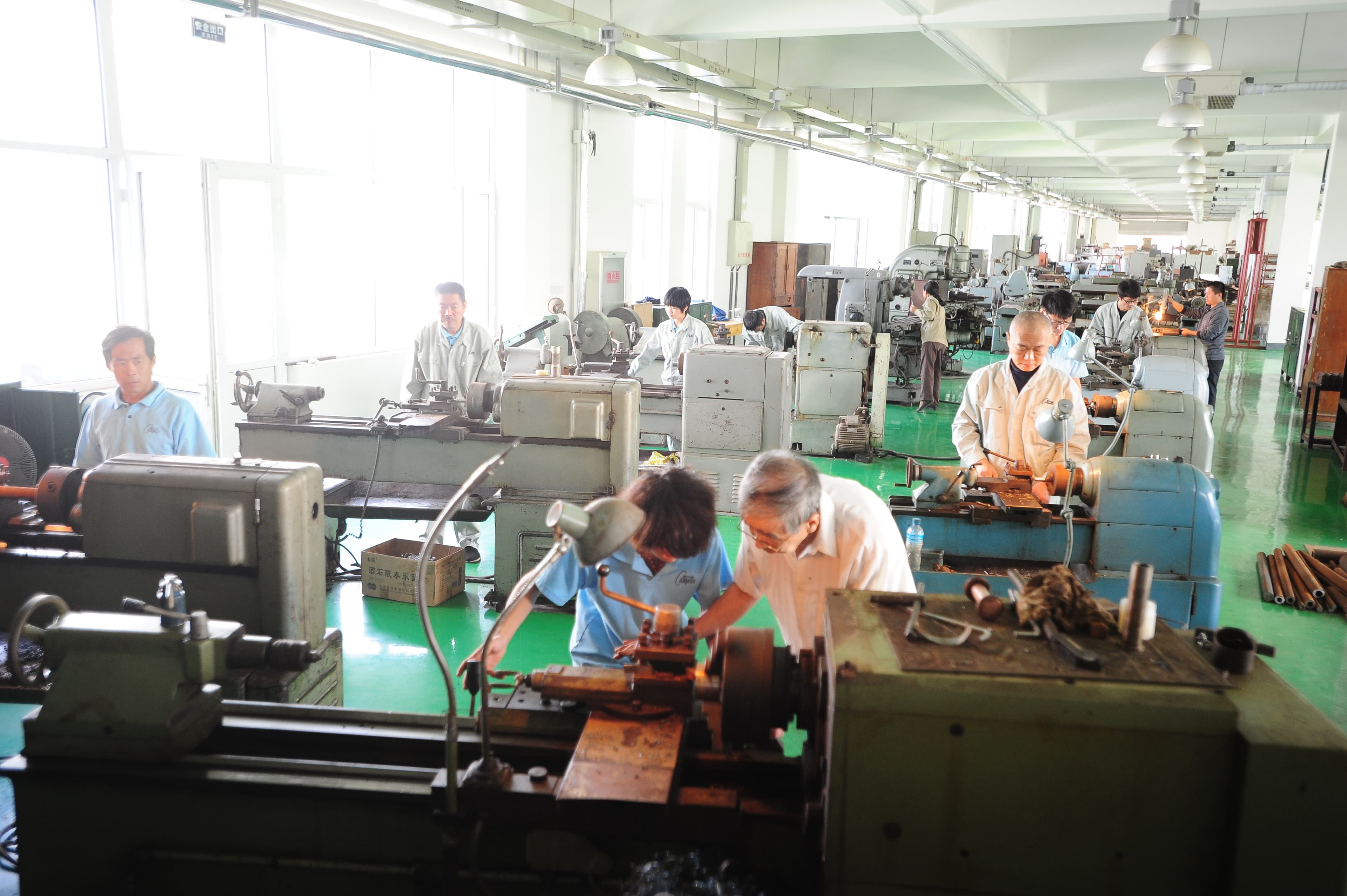 Wide view of the machining workshop and its operators.