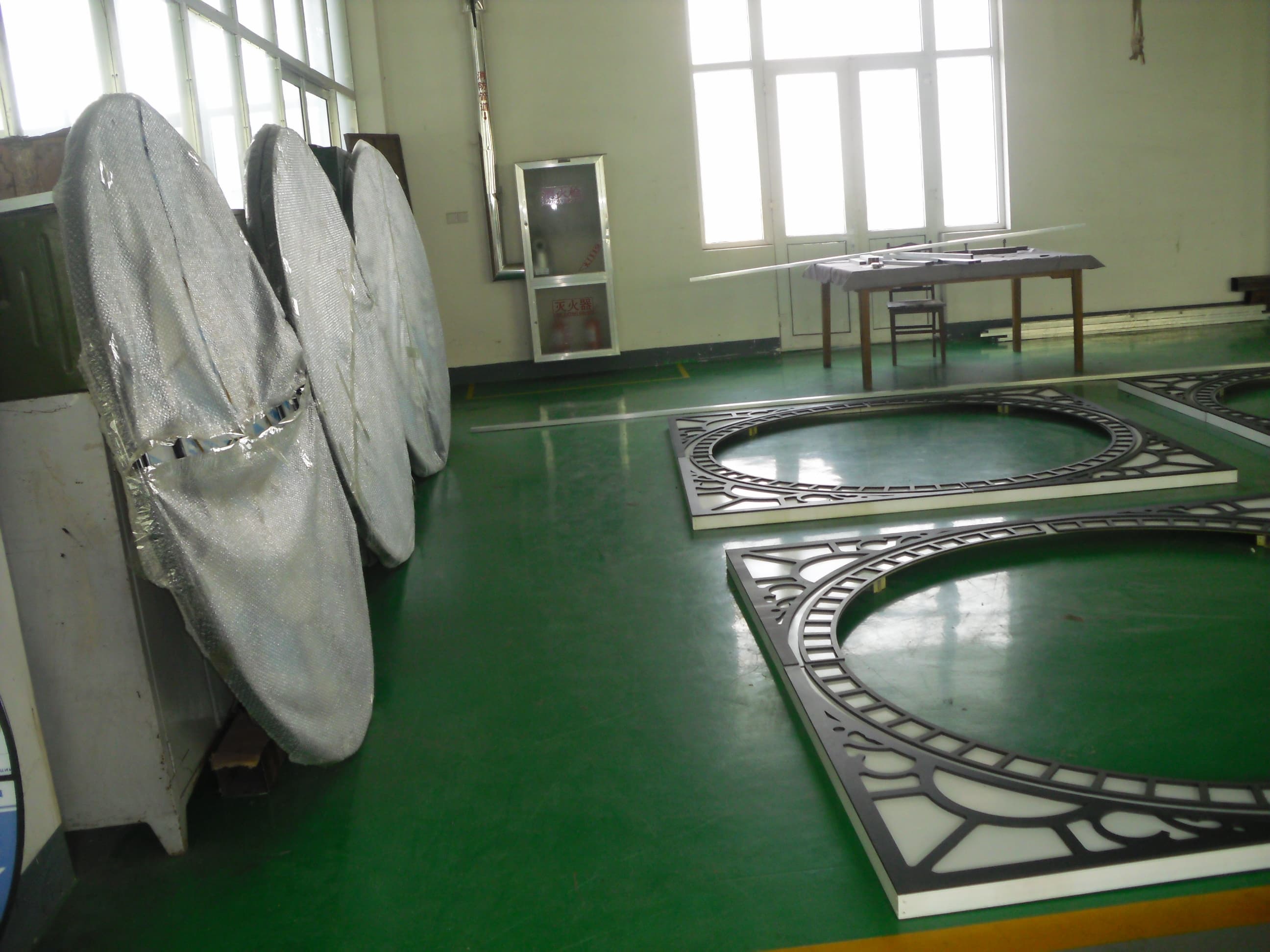 Clock-face rings and segments staged in the production workshop.