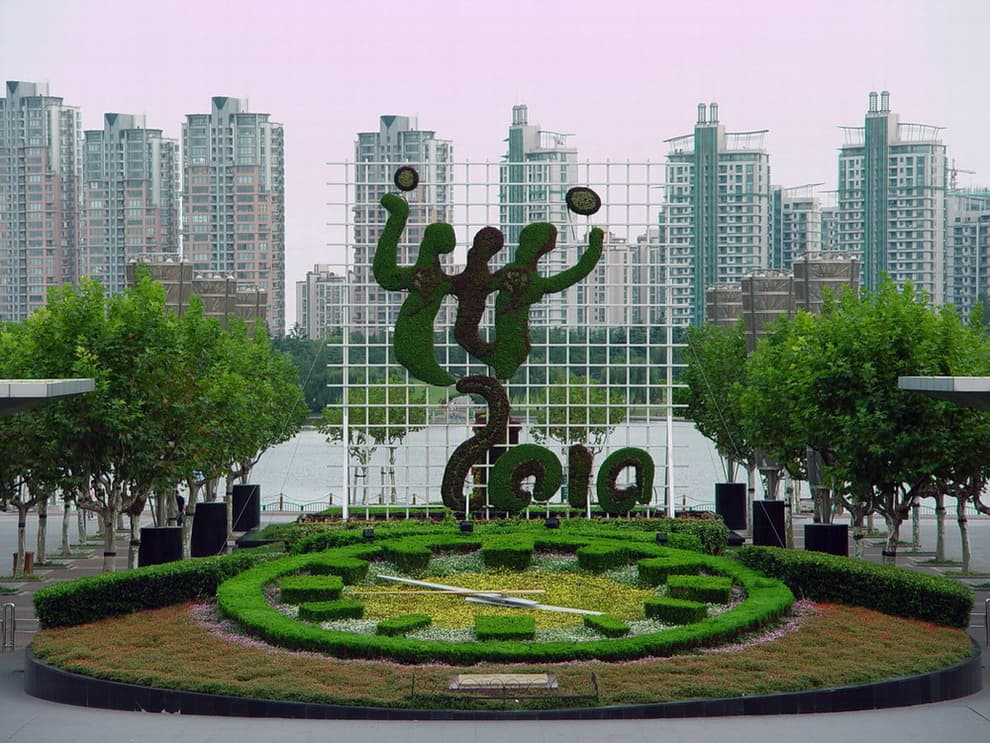 Flower clock arranged in a civic plaza with a city skyline.