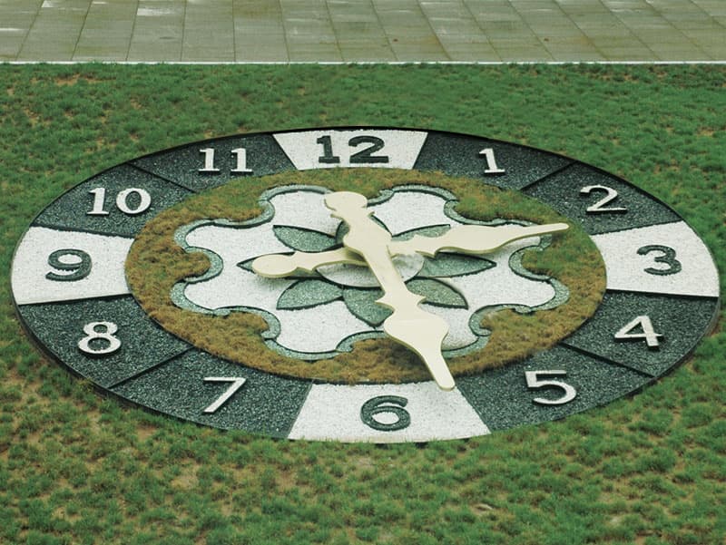 Close view of a floral clock with geometric planting patterns.