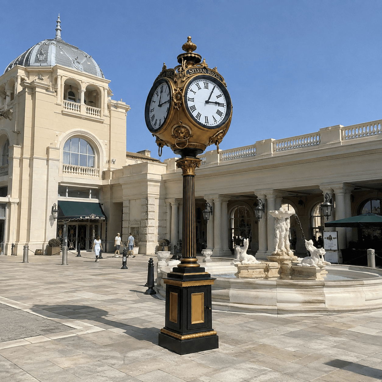 Four-sided gold street clock in a grand public courtyard.